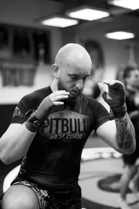 Zawodnik z owijkami na dłoniach przed treningiem boksu w Berserkers Team Rzeszów.